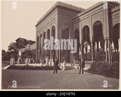 Palais de Gézyret, Pavillon Exterieur 1870s J. Pascal Sébah Türkisch der Gezira Palace befindet sich auf der gleichnamigen Insel im Nil im Zentrum von Kairo. Die Insel wurde zuerst mit üppigen Gärten und einem Sommerpalast von der khedive Ismacil (r. 1863-79), und er wählte es auch als Standort für diesen Palast, der zur Aufnahme der Kaiserin Eugénie von Frankreich für die große Eröffnung des Suezkanals im Jahr 1869 errichtet wurde. Danach sollten dort auch Staatsgäste wie der Prinz und die Prinzessin von Wales und Kaiser Franz Joseph von Österreich-Ungarn untergebracht werden. Der Bau des Palastes dauerte viele Jahre und invol Stockfoto