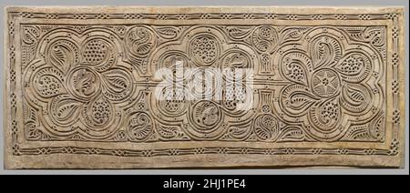 Dado Tafel 10th Jahrhundert Diese geschnitzte Gipsplatte stammt aus einem aufwendig verzierten Haus, das in Nishapur ausgegraben wurde und in dem mehrere Räume den unteren Teil der Wand (Dado genannt) schmückten. Die Paneele waren ursprünglich in hellen Gelb-, Rot- und Blautönen gestrichen, mit ebenso bunten Wandmalereien an den Gipswänden darüber. Sobald die ausgegrabenen Platten jedoch der Luft ausgesetzt waren, verschwanden die hellen Farben schnell. Es scheint, dass für diese Dado-Paneele eine dünne Stuckschicht auf die Wand aufgebracht wurde und das Design mit einem Kompass und anderen Zeichenwerkzeugen skizziert wurde. Dann t Stockfoto
