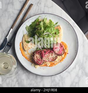 Rucola, vegane Linsenfrittierte Koteletts mit Couscous. Perfekt für die Detox-Diät oder einfach nur eine gesunde Mahlzeit. Stockfoto