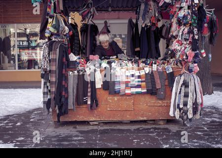 Belgrad, Serbien, 23. Januar 2022: Eine Verkäuferin sitzt hinter einem Straßenstand mit Socken Stockfoto