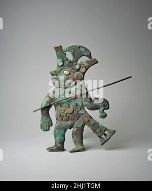 Profil Warrior Ornament 6th–7th Century Moche (Loma Negra) dieser Krieger, einer von fünf sehr ähnlichen vergoldeten Kupferfiguren in den Sammlungen des Metropolitan Museum of Art (die anderen sind die Beitritts-Nummern 1987.394.70, .72, .71, .86), wurde von Künstlern der Moche-Kultur im Norden Perus geschaffen. Jede Figur hat einen Speerwerfer oder ein Atlatl in der Hand und jede trägt eine typische Moche-Kriegerregalia, darunter einen markanten Kopfschmuck, der unter dem Kinn gebunden und von einem Metallsichel überragt wird, der zwischen zwei abgestuften Elementen nach oben ragt. Die Krieger tragen Tunika und Lendenschurz sowie Ohrschmuck Stockfoto