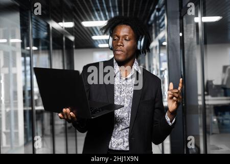 Black Skin dj in Kopfhörern hört Musik, macht DJ Set und Tanz. Party-Lifestyle Stockfoto