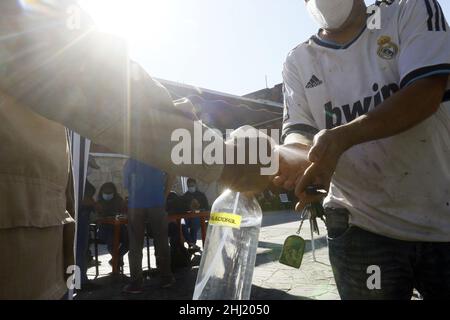 Valencia, Carabobo, Venezuela. 26th Januar 2022. 26. Januar 2022. Ein Milizbeamter sprüht einen Bürger mit antibakteriellem Spray, nachdem er die Aktivierung des Referendums für die Aufhebung des Mandats von Nicolas Maduro unterzeichnet hat. Ein CNE, der Concil National Electoral, (für seine Abkürzung auf Spanisch) das Regierungsorgan, das das Mandat von Nicolas Maduro widerrufen soll. Die Verordnung verlangt die Sammlung von 20% der Unterschriften des Wahlregisters in 12 Stunden, was die Opposition für unmöglich hält. In der Stadt Valencia, Bundesstaat Carabobo. Foto: Juan Carlos Hernandez (Bild: © Juan Carlos Hernandez/ZUMA Pre Stockfoto