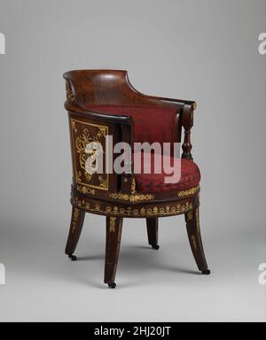 Schreibtischstuhl (fauteuil de Bureau) 1804–14 Französisch in der Mitte des 18. Jahrhunderts stellten französische Menüleute oder Tischler sowohl praktische als auch elegante Stühle her, speziell für den Einsatz hinter einem Schreibtisch. Durch die Änderung der traditionellen Anordnung eines Stuhls schufen sie einen sogenannten fauteuil de cabinet oder Bürosessel. Für mehr Stabilität wurde ein aufrechter Vorderteil aufgestellt, sodass der Benutzer seine Beine auf beiden Seiten anordnen konnte. Mit ihrer geschwungenen Kontur haben diese Stühle eine abgerundete Rückseite, die den Oberkörper unterstützt, während die geschwungenen Arme für zusätzliche Unterstützung vorgesehen sind. Während der zweiten Hälfte des Stockfoto