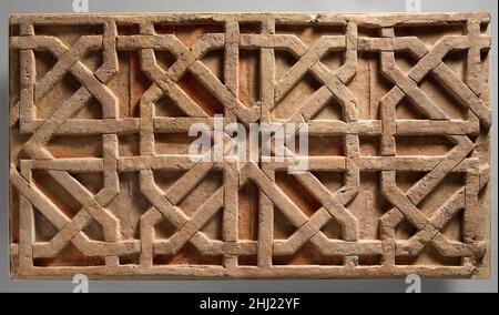 Fragment eines Friezes aus dem 11th. Jahrhundert Diese Terrakotta-Platte wurde in der Umgebung der Tepe Madrasa Moschee in Nishapur gefunden und hat ein achteckiges Muster mit einem Stern in der Mitte. Pigmentreste auf der Oberfläche deuten darauf hin, dass der Hintergrund rot und blau gefärbt war, während die geometrischen Formen im Vordergrund weiß schattiert waren. Terrakotta, in der Regel in Form von Ziegeln, wurde im ganzen Iran als dekoratives Material verwendet, bevor es durch glasierte Fliesen ersetzt wurde. In Nishapur zeugen viele Fragmente großer Terrakotta-Platten, die mit verschiedenen Designs geschnitzt wurden, von einer weiteren Form Stockfoto