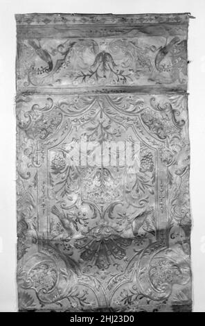 Wandhängefragment erstes Viertel 18th Jahrhundert nach einer Komposition von Daniel Marot dem Älteren Französisch Ein beliebtes Textildesign von Daniel Marot aus der Zeit um 1900. 1712 diente als Inspiration für das Muster von 08.171.1c (bemerkenswert an der Beibehaltung der ursprünglichen Bordüre) und verwandte vergoldete Lederpaneele. Marot, Hofarchitekt von Wilhelm III., beeinflusste zu dieser Zeit die dekorative Kunst in den Niederlanden stark; seine Veröffentlichung von 1702–1715 mehrerer Serien ornamentaler Entwürfe trug zur Popularisierung des Louis-XIV-Stils in den Niederlanden bei. Wandhängefragment 190782 Stockfoto