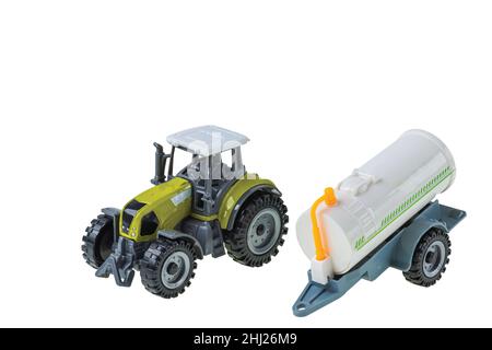 Nahaufnahme von Spielzeugtraktor und Wasseranhänger isoliert auf weißem Hintergrund. Stockfoto