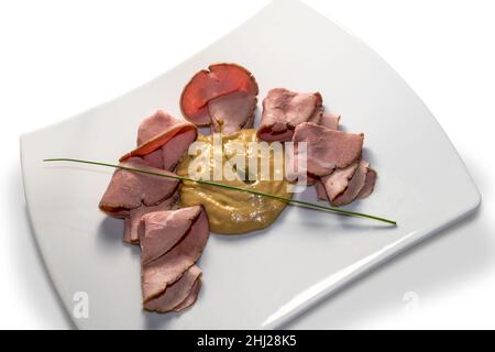 Vitello tonnato, typisch italienisches Roastbeef aus dem Piemont mit eingelegten Kapern, Kalbsscheiben, Mayonnaise-Sauce mit Thunfisch in einer weißen, auf Weiß isolierten Schale Stockfoto