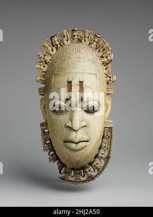 Queen Mother Anhänger Maske: Iyoba 16th Century Edo Volks Diese Elfenbein Anhänger Maske ist eines von zwei fast identischen Werken; ihr Gegenstück befindet sich im British Museum in London. Obwohl Frauenbilder in Benins höflicher Tradition selten sind, symbolisieren diese beiden Werke das Erbe einer Dynastie, das bis heute andauert. Es wird angenommen, dass die Hängemaske im frühen sechzehnten Jahrhundert für den König oder ObaEsigie, den König von Benin, hergestellt wurde, um seine Mutter, Idia, zu ehren. Der oba mag es bei Riten getragen haben, die seiner Mutter gedenken, obwohl solche Anhänger heute im Jahr getragen werden Stockfoto