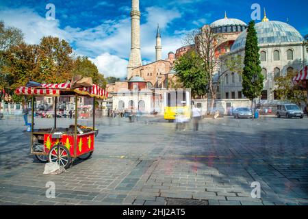 ISTANBUL, TÜRKEI - 24. OKTOBER 2014: Ein Straßenverkäufer verkaufte vor der Hagia-Sophia-Moschee auf dem Sultanahmet-Platz Kastanien und Mais Stockfoto