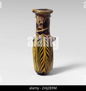 Glas-Alabastron (Parfümflasche) 3rd–2nd Jahrhundert v. Chr. Griechisch, östliches Mittelmeer Durchscheinendes Kobaltblau, mit Griffen in gleicher Farbe; Spur in opakes Gelb.Dicke horizontale Randscheibe, ungleichmäßig geformt mit strahlenden Werkzeugmarkierungen auf der Oberseite; zylindrischer Hals, leicht nach unten zugeneigt; kleine schräge Schulter; gerader zylindrischer Körper; Konvexer Boden; am Oberkörper zwei Ösen-Griffe, über dem Trailmuster angebracht; einer deutlich größer als der andere.Trail oben auf der Randscheibe befestigt, spiralförmig um den Rand gewickelt, dann über den Hals nach unten und über den Körper, wo er in eine Nahform geheftet wird Stockfoto