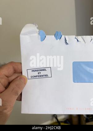 POV männliche Hand mit offenem Umschlag mit Personal und confidentiel-Zeichen, die als persönliche und vertrauliche Informationen übersetzt wurden Stockfoto