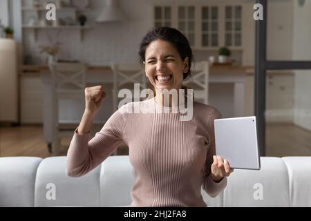 Frau mit Tablet Schreie vor Freude feiern fantastische Nachrichten erhalten Stockfoto