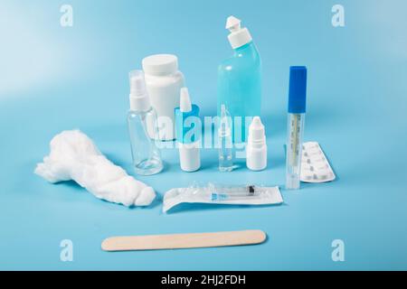 Medicine Set aus verschiedenen Pillen und Tropfen mit Spritze, auf blauem Hintergrund. Stockfoto