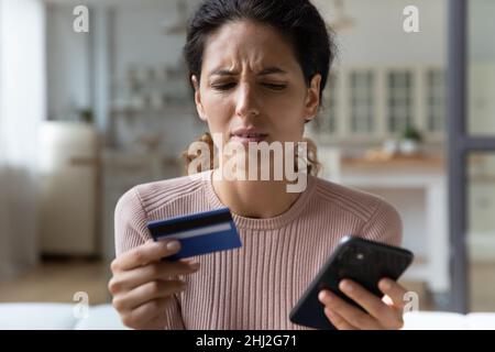 Verrunzelt Frau mit Karte und Handy hat Probleme mit e-payment Stockfoto