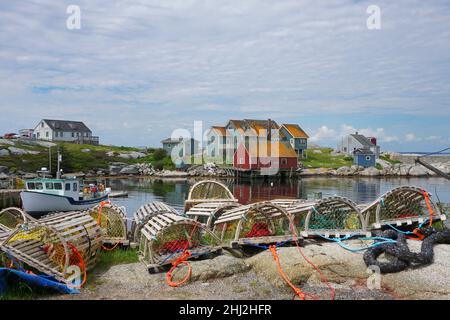 Hölzerne Hummerfallen und ein Fischerboot in Peggys Cove, Nova Scotia, Kanada Stockfoto