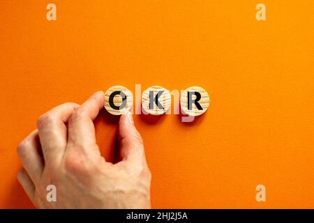 Symbol für OKR, Ziele und Schlüsselergebnisse. Konzeptworte OKR-Ziele und Schlüsselergebnisse auf Holzkreisen auf einem schönen orangefarbenen Hintergrund. Business OKR Stockfoto