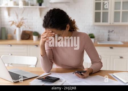 Frau überprüfen persönliche Finanzen, berechnen inländischen Rechnungen fühlt sich gestresst Stockfoto