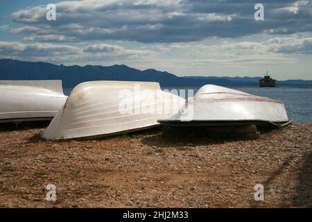 Boote am Ufer des Meeres in Kroatien. Im Hintergrund sind Felsen und blauer Himmel. Stockfoto