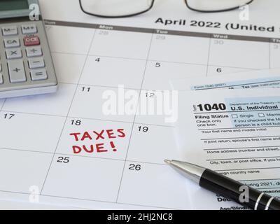 Ein Kalender für 2022, in dem die Frist für die Einreichung von IRS-Einkünften im April 18 für die Steuern im Jahr 2021 angegeben wird, wird aus der Nähe angezeigt. Stockfoto