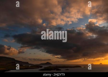 Meeresküste mit den Berggipfeln der Skelligs im Hintergrund und dramatisch bewölktem Himmel, Killarny, County Kerry, Irland Stockfoto