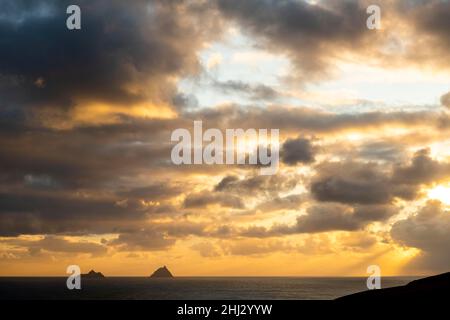 Meeresküste mit den Berggipfeln der Skelligs im Hintergrund und dramatisch bewölktem Himmel, Killarny, County Kerry, Irland Stockfoto