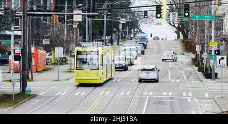 Seattle - 23. Januar 2022; Straßenszene in Seattle als gelbe Straßenbahn speichert Energie und bewegt sich bergab durch regeneratives Brechen Stockfoto