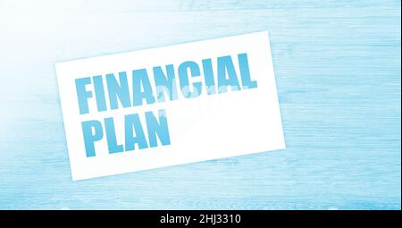 Finanzplan Wörter auf Karte auf Holztisch. Konzept der Geschäftsverschuldung. Stockfoto