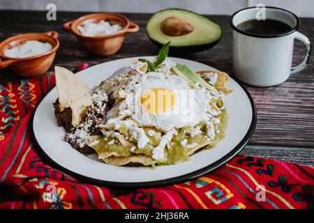 mexikanische grüne Chilaquiles mit Spiegelei, Huhn und würziger grüner Sauce traditionelles Frühstück in Mexiko Stockfoto