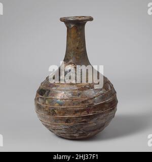 Parfümflasche aus Glas 1st. Jahrhundert n. Chr. römisch farblos mit bläulicher Färbung, mit gleicher Farbspur.Rand ausgeklappt, nach unten, über und nach innen; aufflackernder Mund; Hals dehnt sich nach unten aus, verbindet sich unmerklich mit Kugelkörper; abgerundeter Boden.feine, unmarvertierte Spiralspur von der Basis des Halses nach unten in dreizehn Umdrehungen.intakt, außer für Teile der Spur auf dem oberen Teil des Körpers, und Riss im Hals; Blasen; dicke Emaille-ähnliche Verwitterung, Irideszenz und Lochfraß.. Parfümflasche aus Glas 239625 Stockfoto