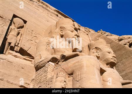 Kolossi von Rameses II und Nefertari in der Fassade der Fassade des Großen Tempels von Ramesses II, Abu Simbel, Ägypten Stockfoto