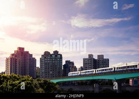 Erhöhter Zug, der über die Brücke fährt. Tolles Stadtbild mit modernem U-Bahn-System. MRT-Reisen durch die Stadt. Taipeh ist ein beliebtes Touristenziel von Stockfoto