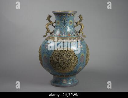 Eines von einem Paar Vasen mit Drachengriffen China Cloisonné aus dem 19th. Jahrhundert ist eine Technik zum Erstellen von Designs auf Metall, bei der Gehäuse aus Kupfer- oder Bronzedraht, die gebogen oder zu einem gewünschten Muster gehämmt wurden, mit farbiger Glaspaste gefüllt werden. Die als Cloisons (französisch für „Trennwände“) bekannten Gehäuse werden in der Regel auf das Metallgehäuse aufgeklebt oder gelötet. Die Glaspaste, oder Emaille, ist mit Metalloxid gefärbt und in die enthaltenen Bereiche eingefärbt. Das Gefäß wird dann gebrannt, meist bei einer relativ niedrigen Temperatur, etwa 800 Grad Celsius. Da die Emaillen gewöhnlich während schrumpfen Stockfoto