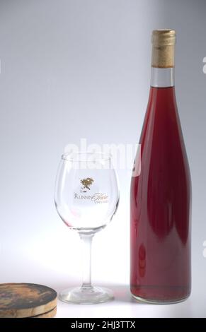 Flasche Rotwein mit Stielglas und Untersetzern mit weißem Hintergrund Stockfoto