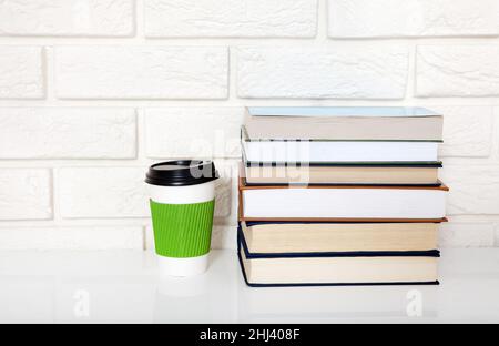 Bildungsliteratur. Tasse Kaffee und Bücher auf dem Tisch in einer Klasse. Draufsicht und Kopierbereich. Stockfoto