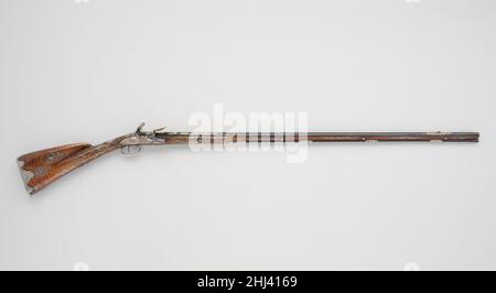 Flintlock Gun ca. 1750 Le Faure French Diese schlanke und elegante Waffe steht für die große Raffinesse von Form, Design und Funktion, die französische Waffenhersteller im 18. Jahrhundert erreicht und in ganz Europa nachgebildet haben. Die filigranen Silberdrahteinlagen des Vorratsbestandes basieren auf französischen Musterbüchern aus dem Jahr 1705, während die geschnitzten und gemeißelten Ornamente von Vorrat, Schloss und anderen Beschlägen eine Vielzahl von Rokoko-Motiven aus Entwürfen zeigen, die erst im Jahr 1740s veröffentlicht wurden. Flintlock Gun. Französisch, Paris. Ca. 1750. Stahl, Gold, Holz (Nussbaum), Silber. Paris. Schusswaffen Stockfoto
