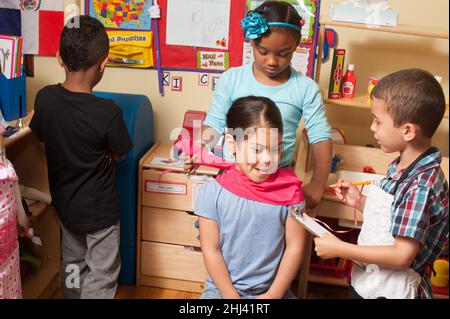 Bildung Vorschule 4-jährige geben vor, spielen Gruppe von Kindern spielen Spiel Mädchen immer Frisur Bestellung Essen vom Koch Stockfoto
