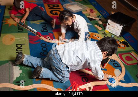Bildung Vorschule 3-4-jährige zwei Jungen und ein Mädchen spielen mit Zug-Set Stockfoto