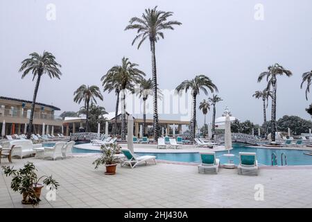 Belek, Antalya, Türkei - 26. Januar 2022: Starker Schneefall an der Mittelmeerküste. Schneesturm und weiß bedeckte Palmen. Leere Strände und Hotel Stockfoto