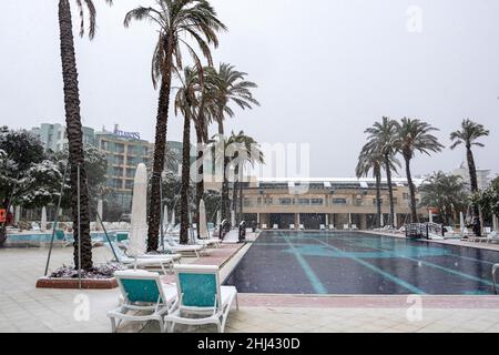 Belek, Antalya, Türkei - 26. Januar 2022: Starker Schneefall an der Mittelmeerküste. Schneesturm und weiß bedeckte Palmen. Leere Strände und Hotel Stockfoto