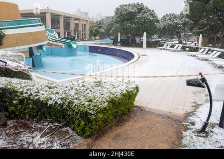 Belek, Antalya, Türkei - 26. Januar 2022: Starker Schneefall an der Mittelmeerküste. Schneesturm und weiß bedeckte Palmen. Leere Strände und Hotel Stockfoto