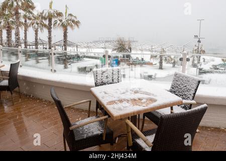 Belek, Antalya, Türkei - 26. Januar 2022: Starker Schneefall an der Mittelmeerküste. Schneesturm und weiß bedeckte Palmen. Leere Strände und Hotel Stockfoto