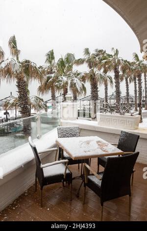 Belek, Antalya, Türkei - 26. Januar 2022: Starker Schneefall an der Mittelmeerküste. Schneesturm und weiß bedeckte Palmen. Leere Strände und Hotel Stockfoto