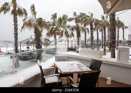 Belek, Antalya, Türkei - 26. Januar 2022: Starker Schneefall an der Mittelmeerküste. Schneesturm und weiß bedeckte Palmen. Leere Strände und Hotel Stockfoto