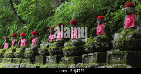 Impresive japanische Wahrzeichen - ausgerichtete buddhistische Jizo-Statuen in Nikko, Japan. Das Foto wird bei Langzeitbelichtung in der Dämmerung aufgenommen. Stockfoto