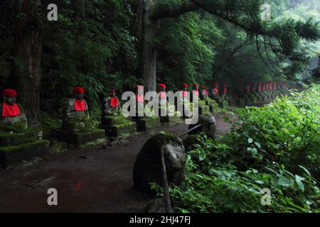 Impresive japanische Wahrzeichen - ausgerichtete buddhistische Jizo-Statuen in Nikko, Japan. Das Foto wird bei Langzeitbelichtung in der Dämmerung aufgenommen. Stockfoto