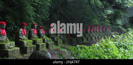 Impresive japanische Wahrzeichen - ausgerichtete buddhistische Jizo-Statuen in Nikko, Japan. Das Foto wird bei Langzeitbelichtung in der Dämmerung aufgenommen. Stockfoto