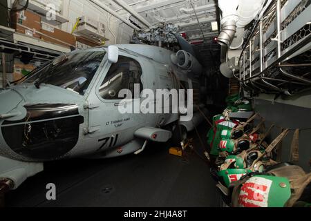 SÜDCHINESISCHES MEER (JAN 24, 2022) ein MH-60R Seahawk-Hubschrauber, der den „Raptors“ von Helicopter Maritime Strike Squadron (HSM) 71 zugewiesen wurde, ruht im Hangar an Bord des Arleigh Burke-Klasse Lenkraketen-Zerstörers USS Spruance (DDG 111). Carl Vinson und Abraham Lincoln Carrier Strike Groups führen duale Carrier-Operationen durch, um die Interoperabilität der Joint Force zu verbessern und gleichzeitig unser Engagement für einen freien und offenen Indo-Pazifik-Raum zu demonstrieren. Die US-Indo-Pacific Command Joint Force sucht routinemäßig nach Möglichkeiten, um Frieden und Stabilität für alle Nationen zu unterstützen. (USA Navy Foto von Mass Communication S Stockfoto