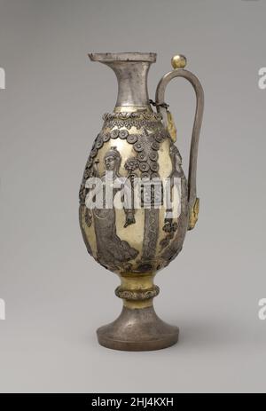 Ewer mit tanzenden Weibchen in Arkaden ca. 6th.–7th. Jahrhundert n. Chr. Sasanian späten Sasanian Silbergefäße, insbesondere Flaschen und Mutterschafe, wurden oft mit weiblichen Figuren mit einer Vielzahl von festal Objekte geschmückt. Das Aussehen dieser Motive zeugt von dem anhaltenden Einfluss griechischer Bildwelten, die mit dem weingott Dionysus verbunden sind. Auf diesem silbervergoldeten Gefäß umrahmen Blumenbögen, unterstützt von niedrigen Pilastern, vier tanzende weibliche Figuren. In jeder Hand befindet sich ein zeremonielles Objekt: Trauben- und Blattäste, ein Gefäß, eine herzförmige Blume. Unter einer Arkade picken Vögel nach Obst und beneat Stockfoto