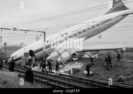 Das Wrack eines vollbeladenen Passagierflugzeugs Viscount, nachdem es die Start- und Landebahn am Rochford Airport übergeschossen hatte und auf der Bahnlinie, die am Flughafen entlang verläuft, landete. Feuerwehrmänner und Rettungsdienste machen den Passagieren den Weg frei, das Flugzeug zu verlassen. Oktober 1960. Stockfoto